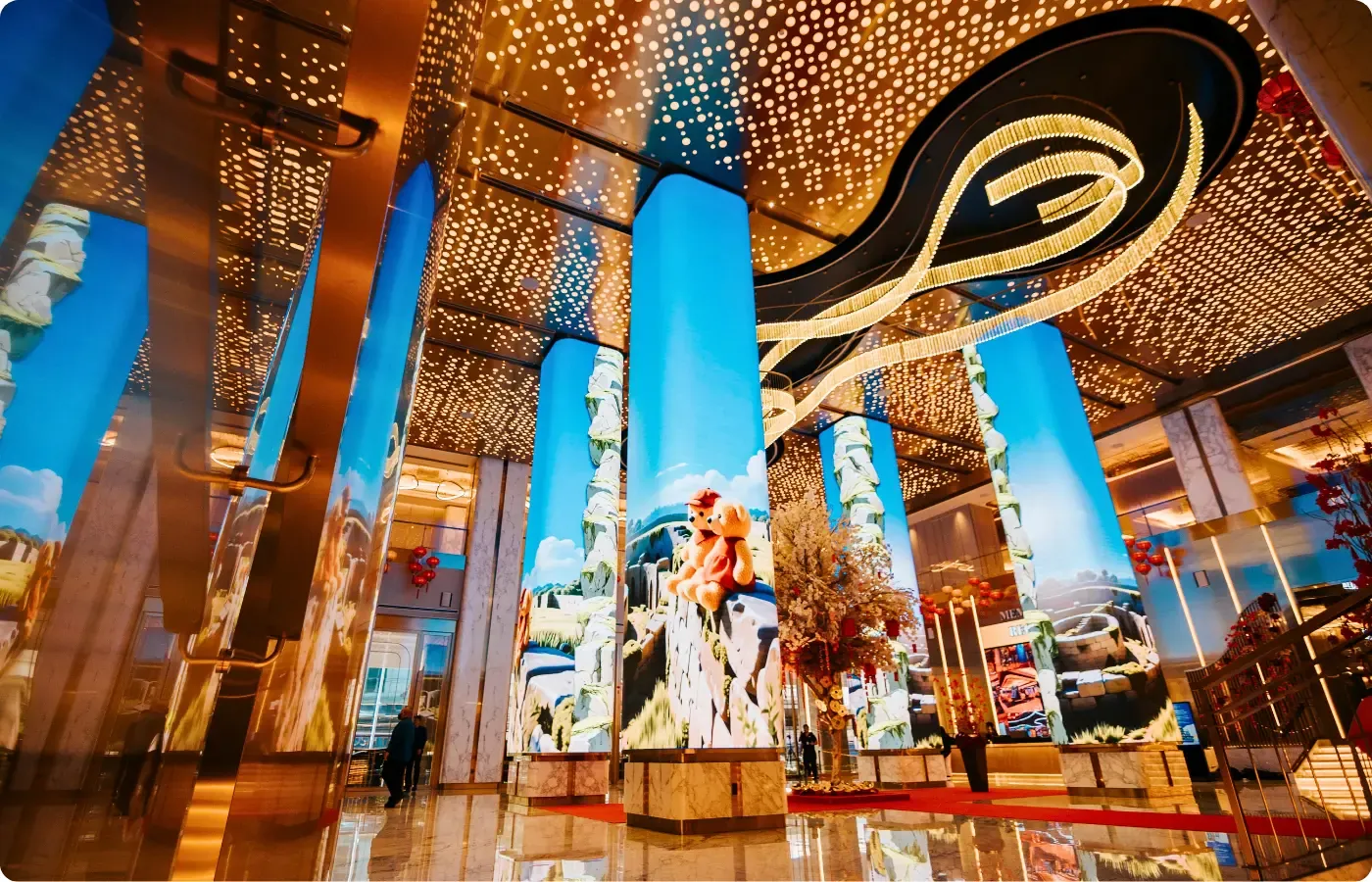 LED-wrapped columns and suspended artwork in a casino grand lobby