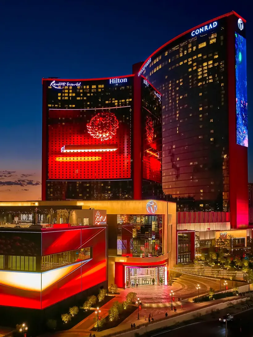 Resorts World Las Vegas towers lit at dusk with LED facade media