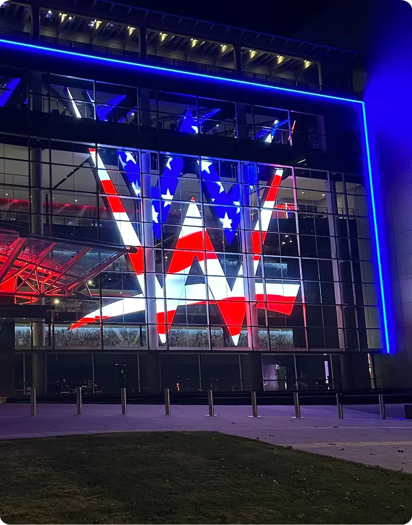 Custom LED WWE logo glowing inside the glass lobby of WWE World Headquarters