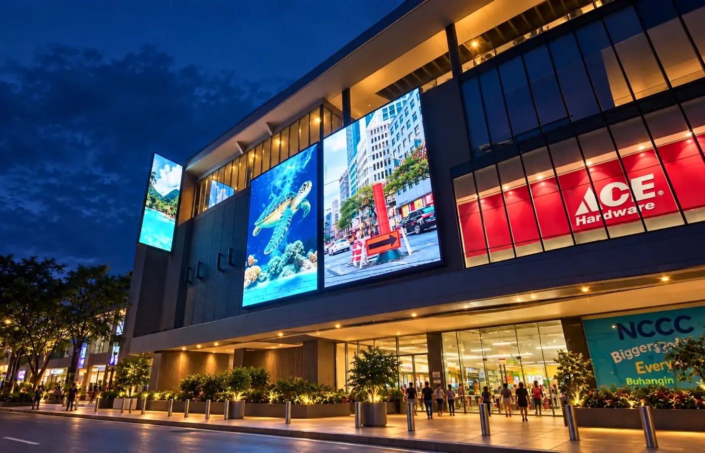 Shopping mall facade with large LED displays at dusk